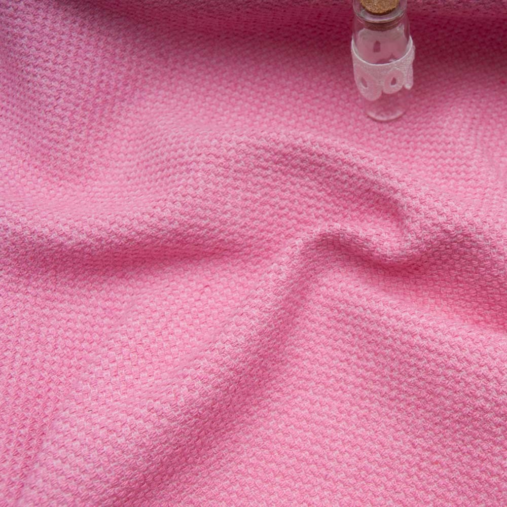 Tweed haut de gamme rose, texture bouclée, avec un petit flacon en verre